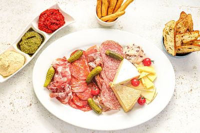 Charcuterie Cheese Board with Pickles, Dips & Cured Meats.