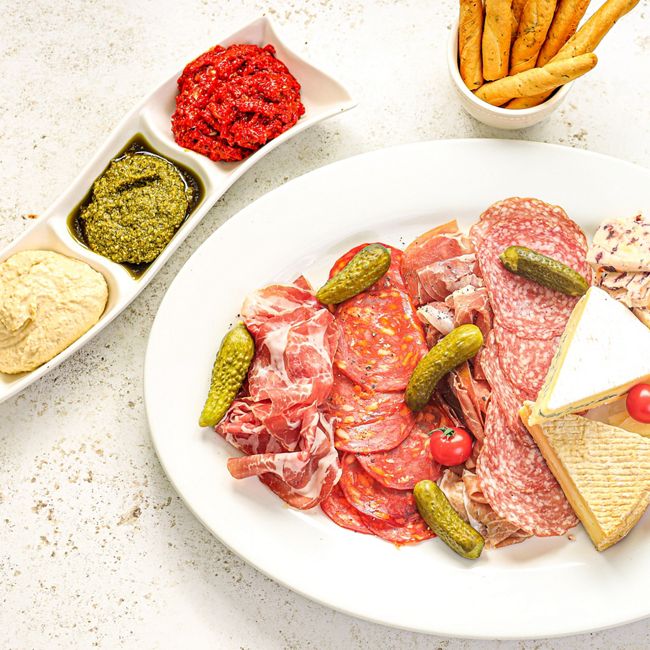 Charcuterie Cheese Board with Pickles, Dips & Cured Meats.