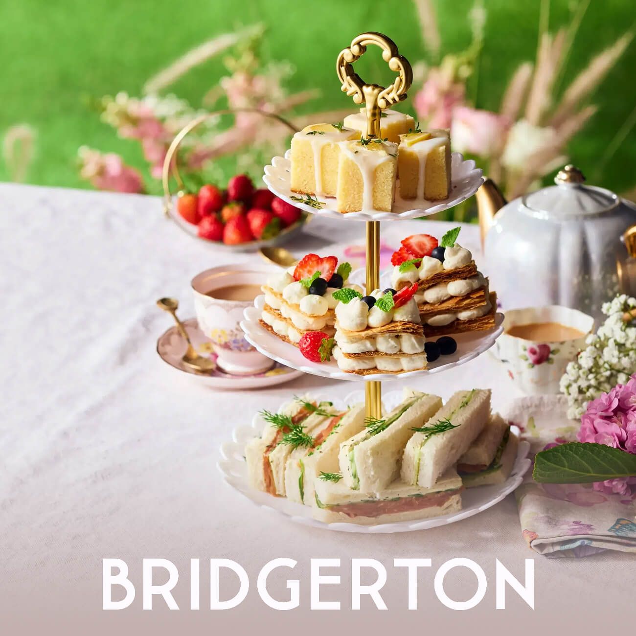 A three-tier cake stand with sandwiches and pastries for a Bridgerton-themed tea, featuring the show's title.
