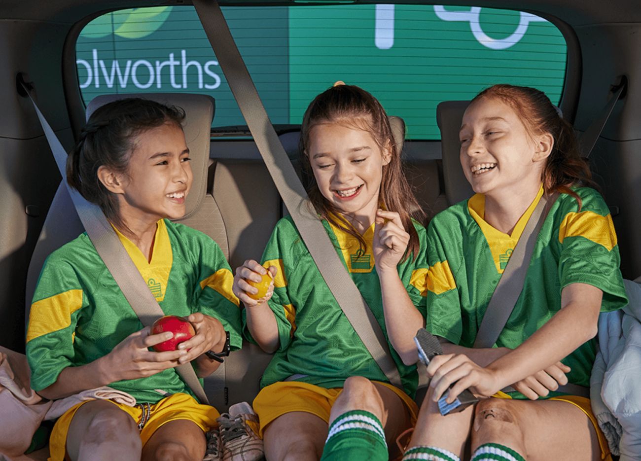 Young girls in sports uniform in car