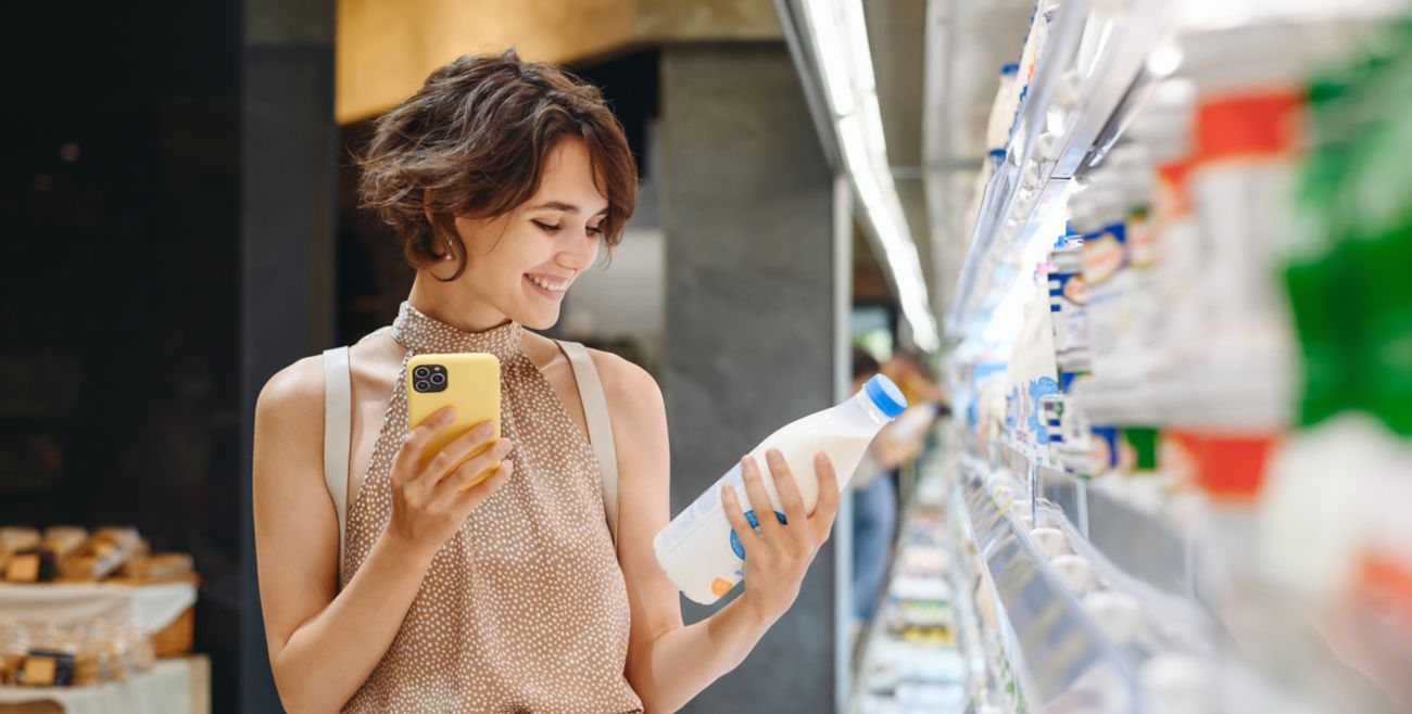Woman checking use-by date in supermarket