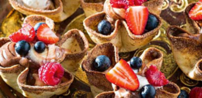 Crispy cinnamon pastry cups filled with chocolate mousse and cream, topped with fresh strawberries, blueberries and raspberries.