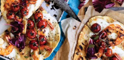 Flatbreads topped with grilled prawns, blistered cherry tomatoes, melted cheese, purple salad leaves and a sprinkle of chilli flakes.