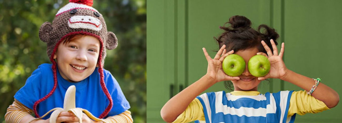A boy's holding a banana, and a girl's holding two apples.
