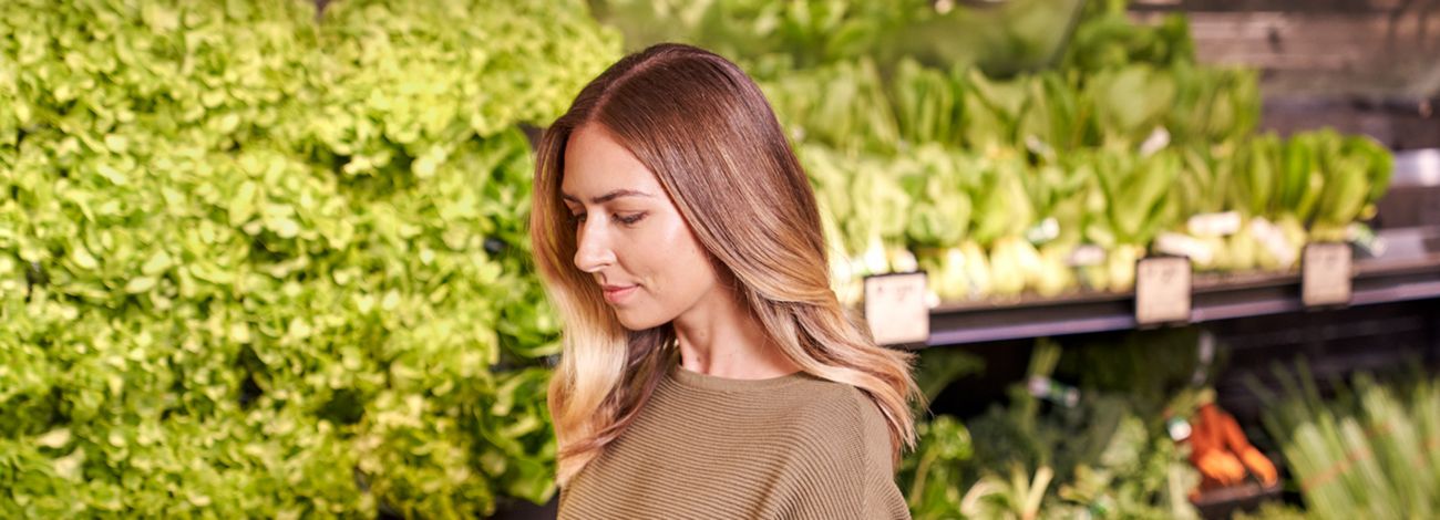 Woman using Scan and Go mobile on broccolini